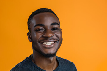 Obraz premium A man in a black shirt is smiling in front of an orange background
