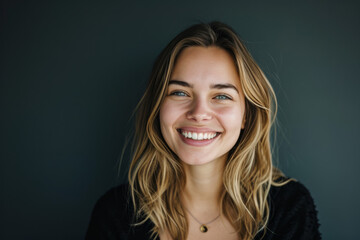 A woman with blonde hair and green eyes smiles for the camera