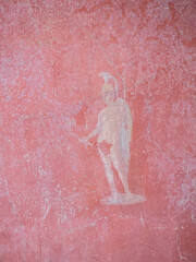 Fototapeta na wymiar Detail of a fresco depicting a warrior in red background at the House of Octavius Quartio, Pompeii