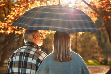 Senior couple walking in the park in autumn