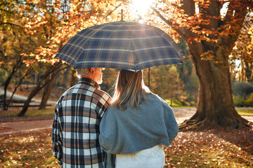 Senior couple walking in the park in autumn - obrazy, fototapety, plakaty