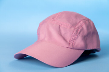 Pink women's cap on blue background. Sport concept. Women's cap concept.