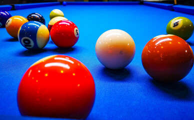 Pool balls on a blue pool table in ongoing game. Vivid colors.