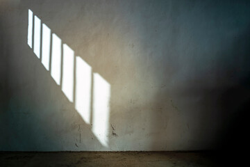 DARK CELL IN JAIL OR PRISON WITH SUNLIGHT THROUGH THE BARRED WINDOW. PRISONER SERVING SENTENCE. - obrazy, fototapety, plakaty