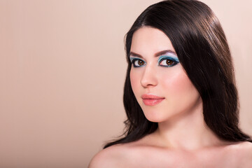 Fototapeta premium Beautiful brunette girl with long curly hair