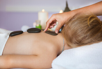 Fototapeta premium Little girl back receiving hot stone massage