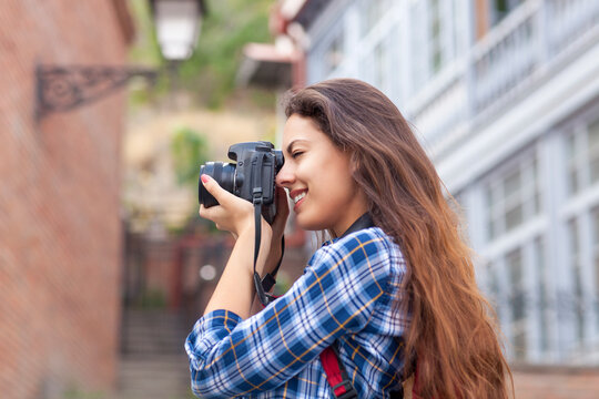 Outdoor summer smiling lifestyle portrait of pretty young woman having fun in the city in Europe