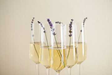Glasses of champagne decorated with lavender on blurred background