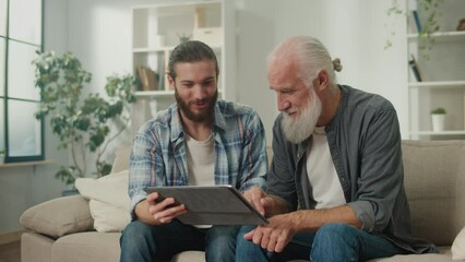 Young volunteer teaches senior how to use a tablet, bridging generation gap, tech-savvy youth, elderly learning, digital literacy, cross-age friendship, modern gadgets