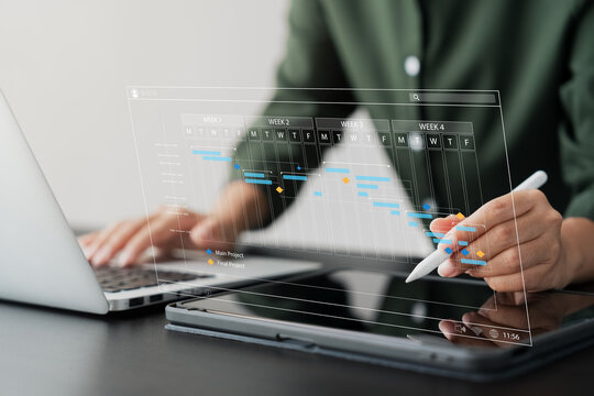 concept of time management and human resources Effectively, businesswoman using a laptop and tablet computer Organizing work in a systematic way.