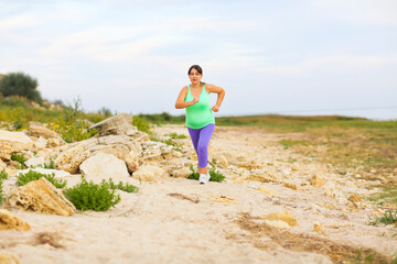 Beautiful pregnant woman doing sport in summer evening