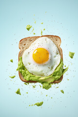Crisp toast with creamy avocado and a perfectly fried egg, with avocado pieces artfully suspended against a clear blue sky background.
