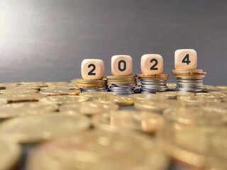 Finance and Economy Concept. 2024 text on wooden cubes on coins stack background.