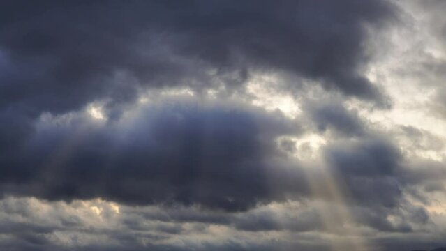 4K Time lapse, beautiful sky with dark blue clouds background. Sky with clouds. Rays of the sun shine through the clouds.
