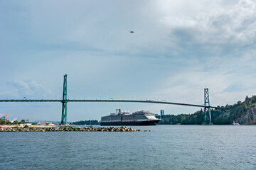 View of ocean harbor with huge ocean cruise liner passing Lion Gates Bridge