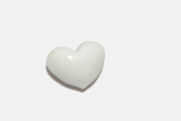 Three-dimensional glossy white heart, close-up.