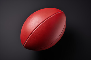 Red Australian rules football on a black background.