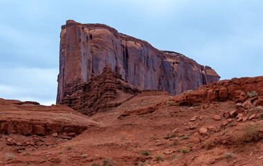 Desert landscape with red rocks and dry vegetation on red sands in Monument Valley, Navajo Nation,  Arizona - Utah