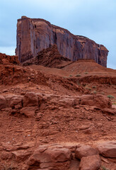 Desert landscape with red rocks and dry vegetation on red sands in Monument Valley, Navajo Nation,  Arizona - Utah