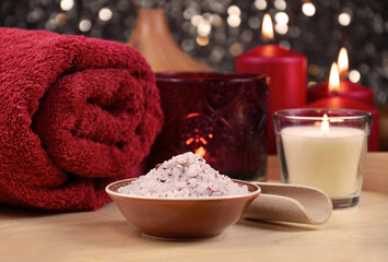 Obraz na płótnie Canvas Bath salt, red towel and candle on wooden background spa still life stock photo images. Romantic spa and wellness setting with towel, bath salt and red candles photo. Beauty spa treatment composition
