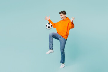 Full body excited fun cool young man fan wears orange hoody casual clothes cheer up support...