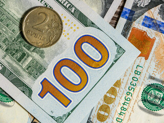 The Russian coin lies on dollar bills.