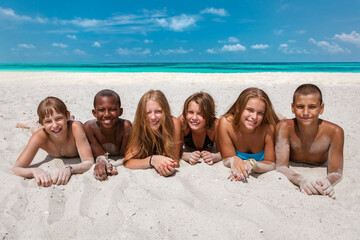 Cheerful group of children on the sandy beach - 714839411