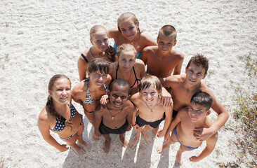 Cheerful group of children on the sandy beach - 714839481
