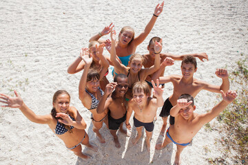 Cheerful group of children on the sandy beach - 714839490