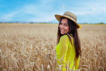 young girl in a hat in a wheat field - 714840813