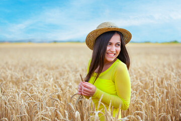 young girl in a hat in a wheat field - 714840815