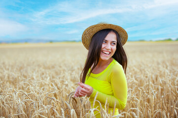 young girl in a hat in a wheat field - 714840878