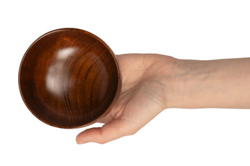 Female hand is holding a wooden bowl isolated on a white background.