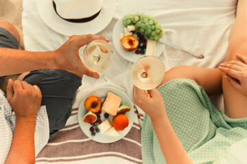 Crop couple drinking wine during picnic