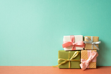 Colorful gift box on red table. mint green wall background