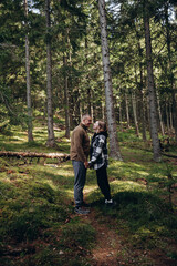 Fototapeta na wymiar family young couple in the mountains, autumn forest. a man and a woman went to the mountains. clothes and shoes for trekking. Man and a woman went on a mountain trip. CARPATHIAN MOUNTAINS