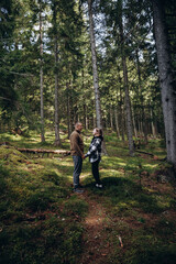 Fototapeta premium family young couple in the mountains, autumn forest. a man and a woman went to the mountains. clothes and shoes for trekking. Man and a woman went on a mountain trip. CARPATHIAN MOUNTAINS