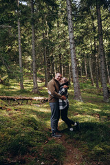 family young couple in the mountains, autumn forest. a man and a woman went to the mountains. clothes and shoes for trekking. Man and a woman went on a mountain trip. CARPATHIAN MOUNTAINS