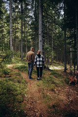 Obraz premium family young couple in the mountains, autumn forest. a man and a woman went to the mountains. clothes and shoes for trekking. Man and a woman went on a mountain trip. CARPATHIAN MOUNTAINS