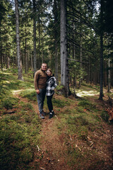 Obraz premium family young couple in the mountains, autumn forest. a man and a woman went to the mountains. clothes and shoes for trekking. Man and a woman went on a mountain trip. CARPATHIAN MOUNTAINS