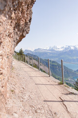 Fototapeta na wymiar Dirt trail at Mount Rigi, Switzerland, overlooking a lake and the Swiss Alps