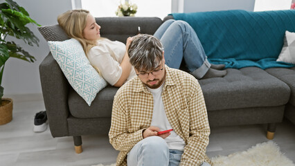 A man and woman relax on a couch in a cozy living room, exuding a sense of togetherness and comfort.