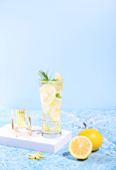 fresh lemon water in glass with lemon slices fruits on sea beach with. Summer sea vacation and travel concept. Exotic summer drinks.
