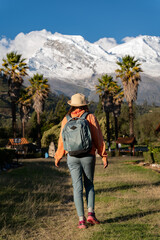 Fototapeta na wymiar Tourist walks through the town named Yungay with the snow-capped Huascaran in the background.