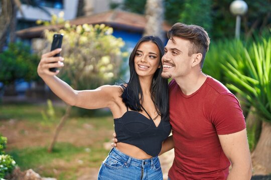 Man and woman couple smiling confident make selfie by smartphone at park