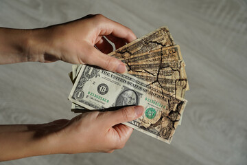 USD fall, bill dollar cracked, financial depreciation, money concept. Woman holding US dollars,...