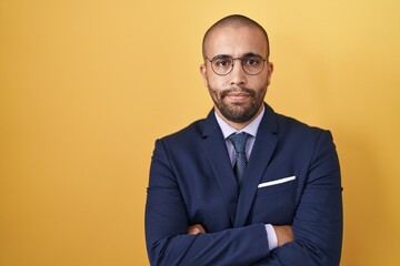 Hispanic man with beard wearing suit and tie skeptic and nervous, disapproving expression on face...