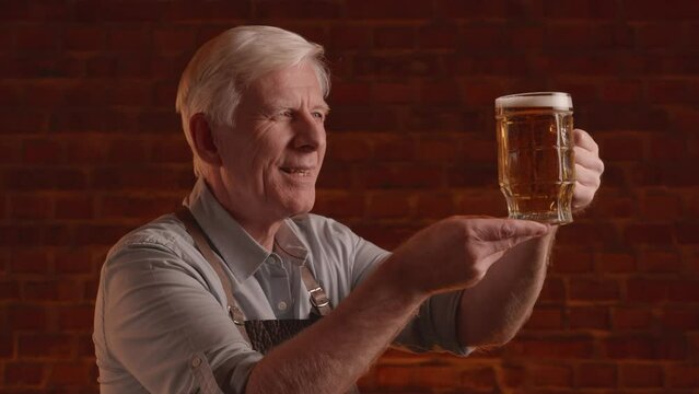 adult blond brewer inspects and tasting fresh beer 