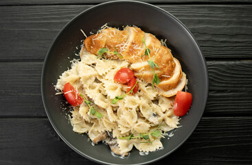 Farfalle pasta in cream sauce with chicken and tomatoes. Chicken italian bow tie pasta. Homemade italian food concept.