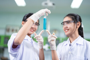 Two female scientists are doctors who point out that a test tube contains a vaccine. In the...